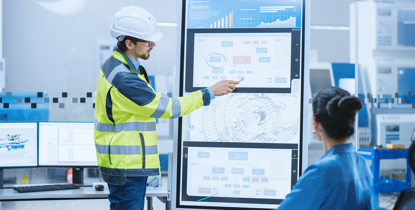 Person wearing PPE making a report at a meeting