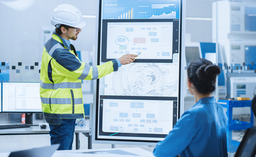 Person wearing PPE making a report at a meeting