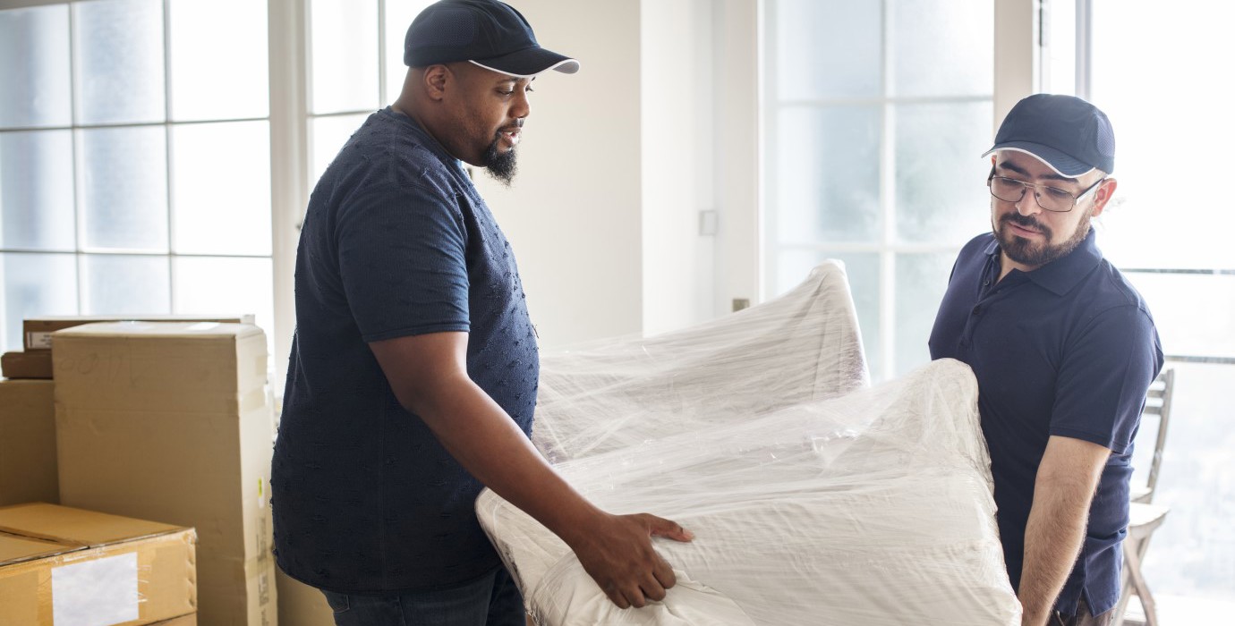 Two movers carrying furniture. 