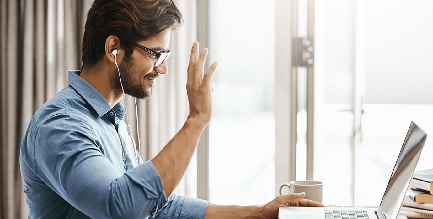 Person waving to someone on laptop