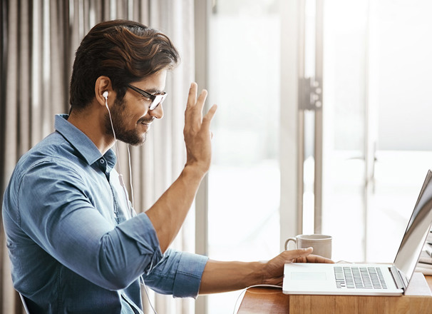 Person waving to someone on laptop