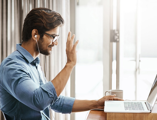 Person waving to someone on laptop