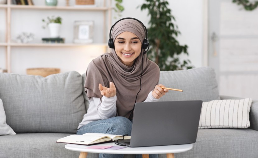 Person interviewing someone on laptop while sitting on couch.