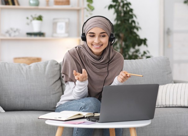 Person interviewing someone on laptop while sitting on couch.