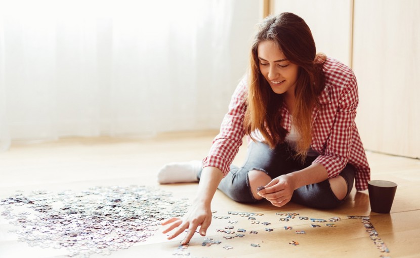 Person doing a puzzle on the floor.