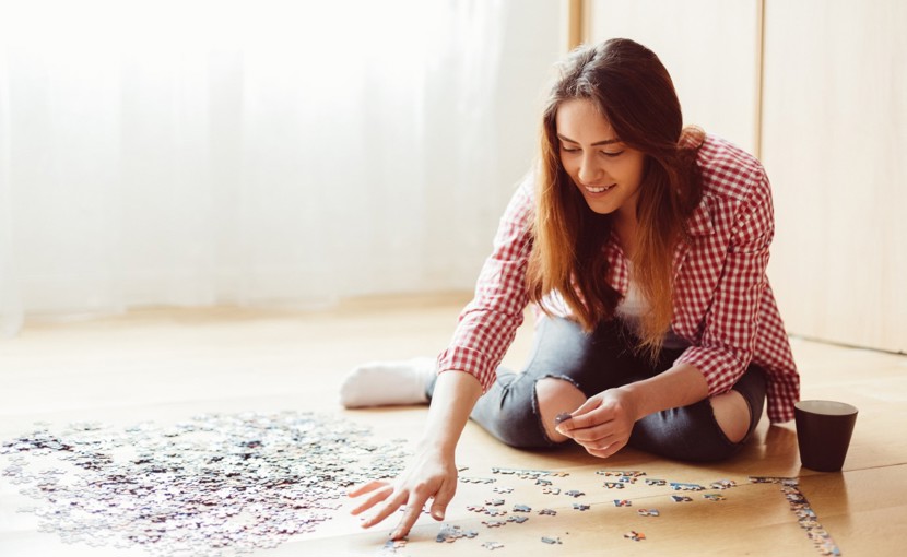 Person doing a puzzle on the floor.