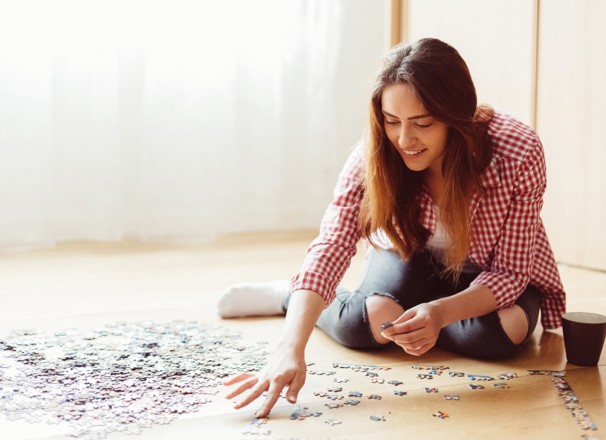 Person doing a puzzle on the floor.