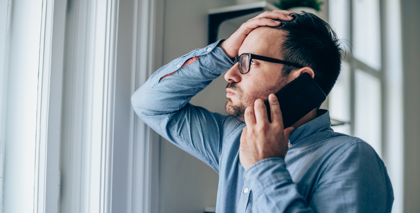 Man looking worried while talking on cell phone.