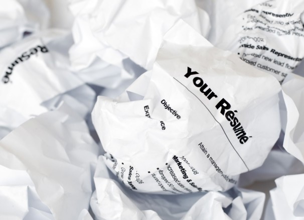 A crumpled resumé in a pile of rejected resumés.