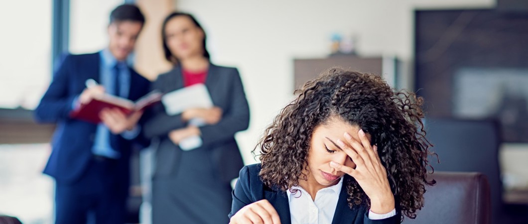 Office worker looking stressed as 2 managers watch over and take notes.