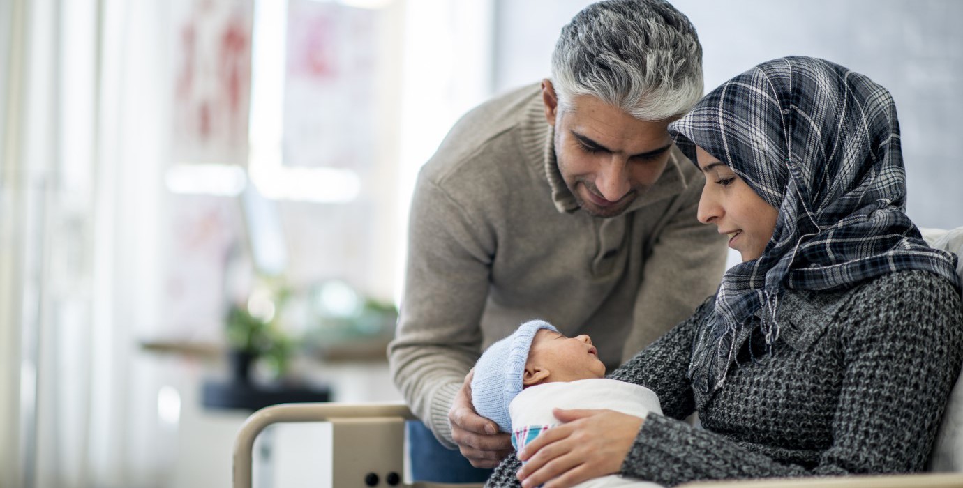 Parents holding their new baby in the hospital.