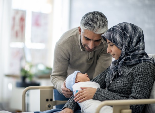 Parents holding their new baby in the hospital.