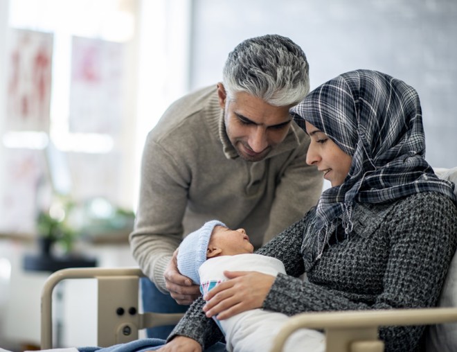Parents holding their new baby in the hospital.