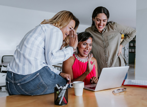 3 employees at computer waving