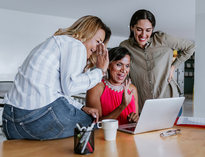 3 employees at computer waving