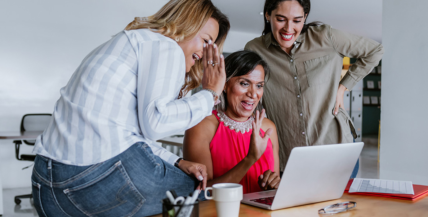 3 employees at computer waving