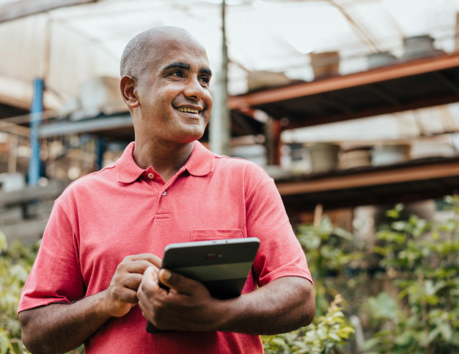 business owner in plant shop with laptop
