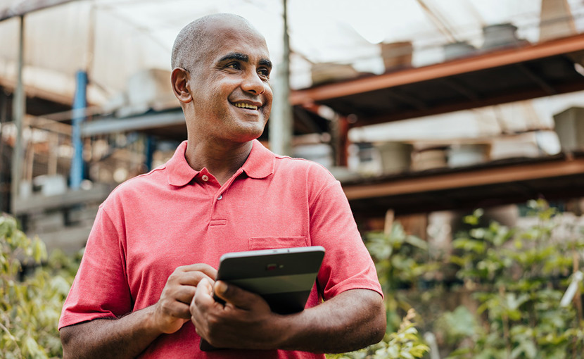 business owner in plant shop with laptop