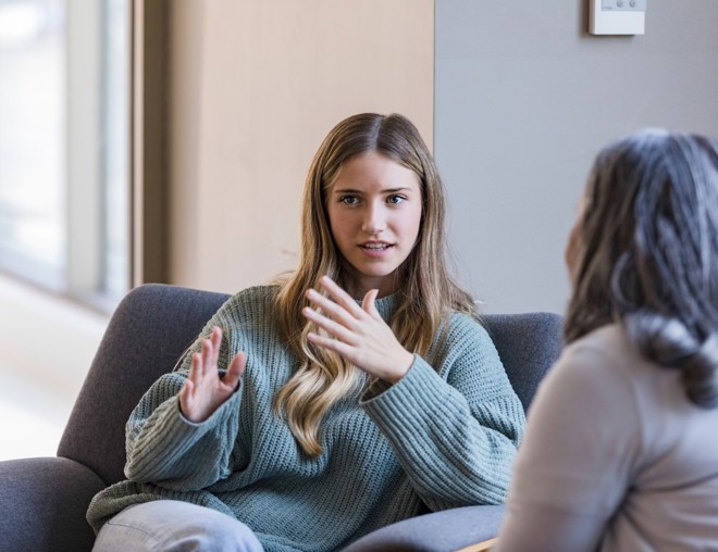 Students sitting on a couch and talking.