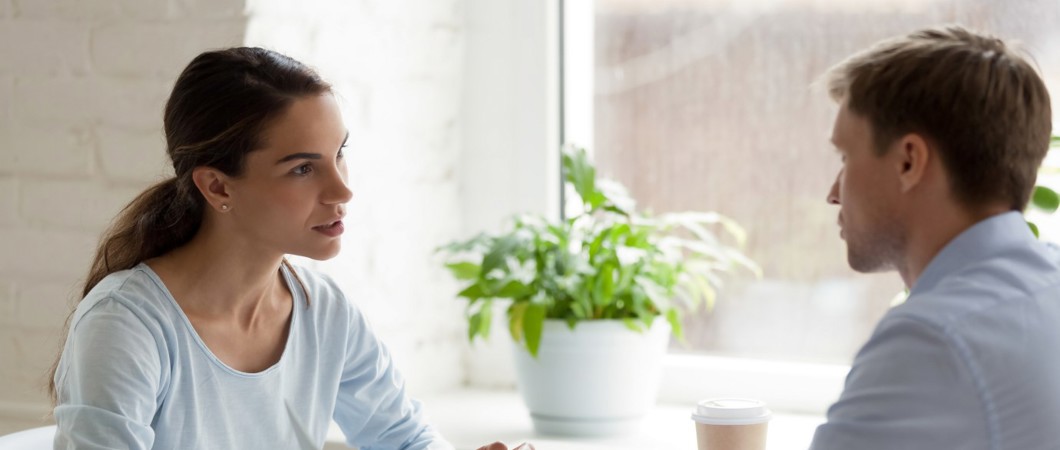 Coworkers talking at a table in the office.