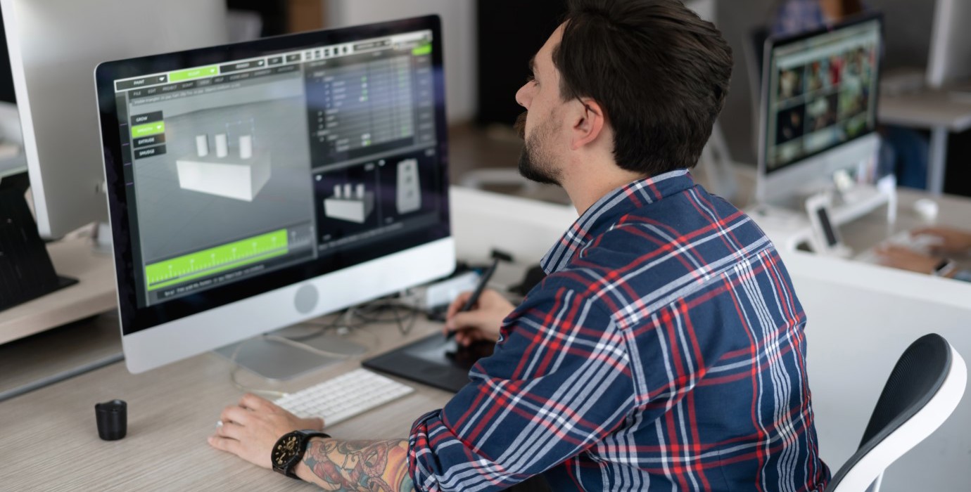 Digital designer working on a 3D model on computer in office.