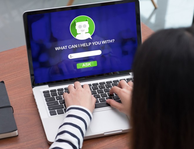 Person typing a question into a chatbot on a laptop.