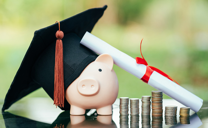 Scholarship concept with mortarboard, diploma, coins and piggy bank