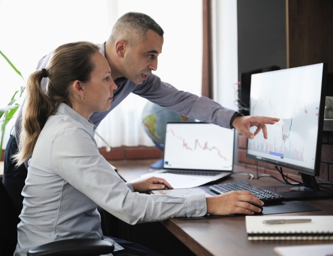 Business people working in the office, viewing data on a desktop computer.