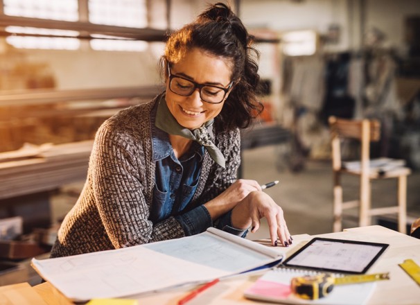 Engineer reviewing blueprints at their desk.