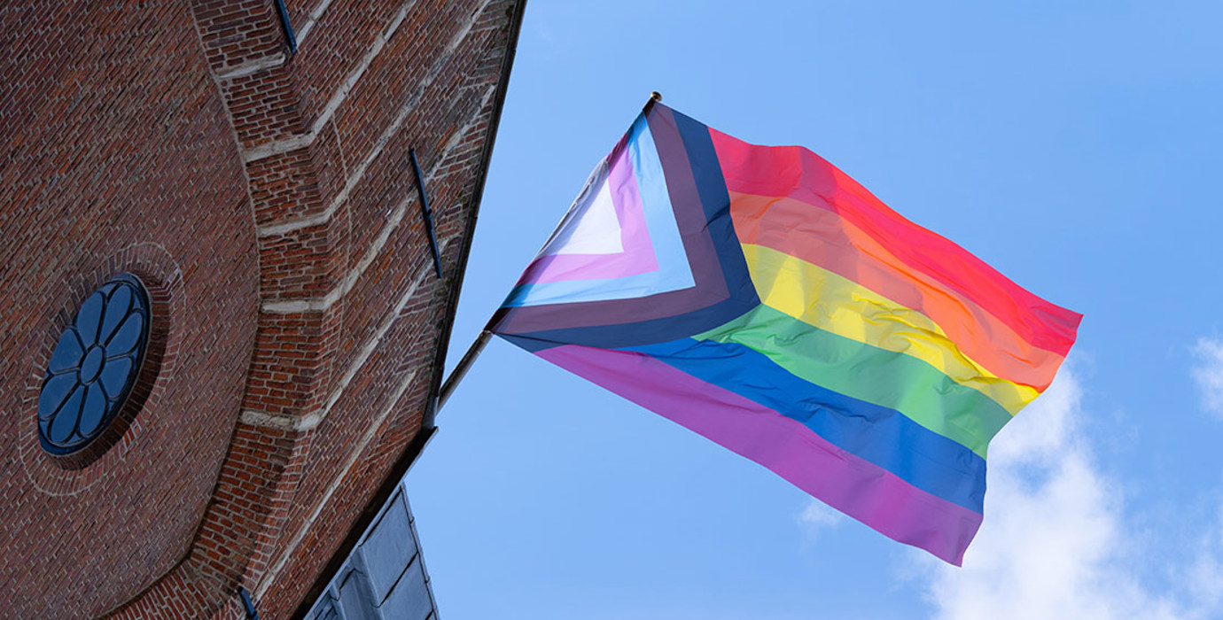 Pride flag flying on outside of building