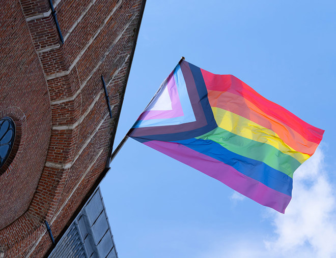 Pride flag flying on outside of building