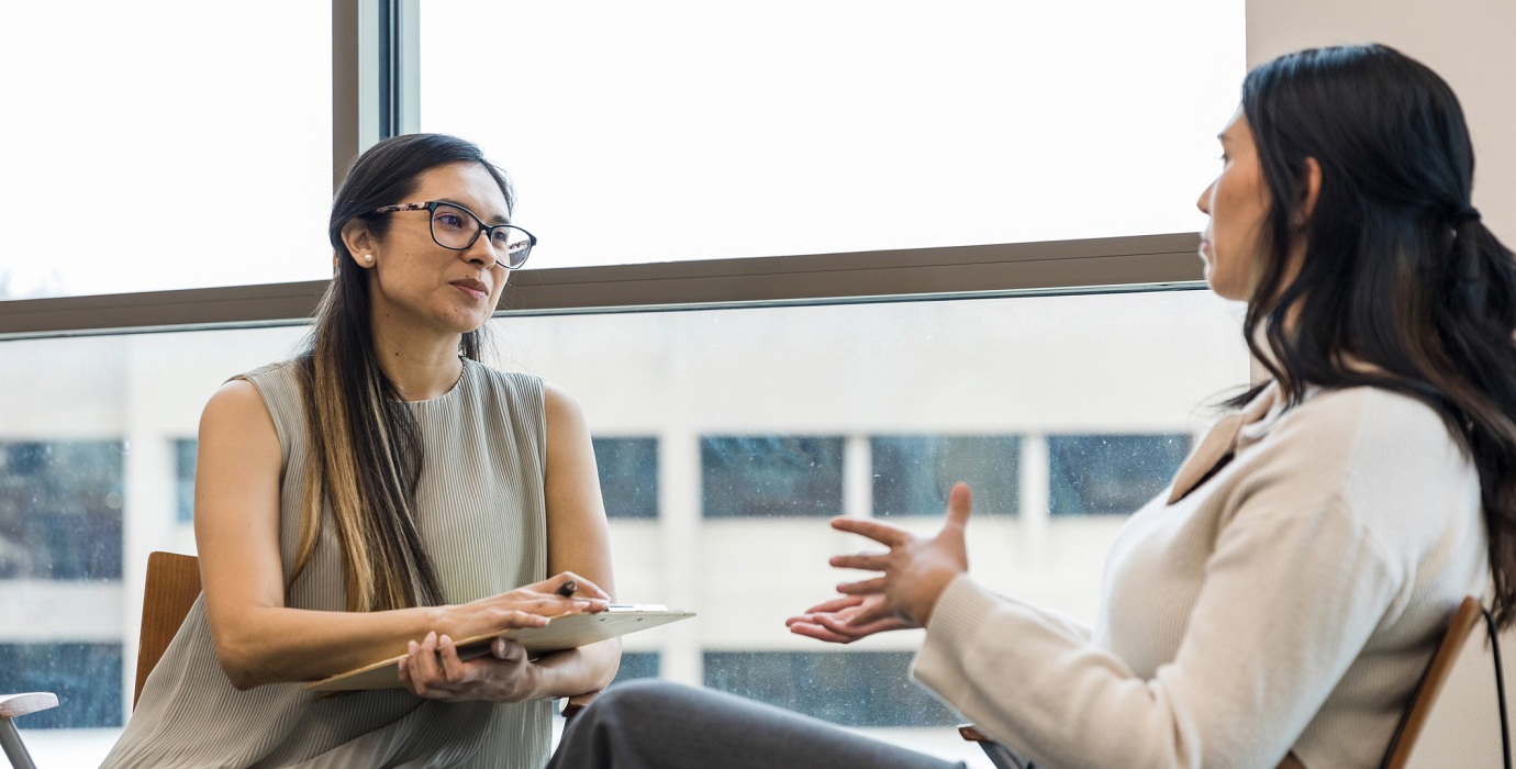 Person interviewing an employee in an office.