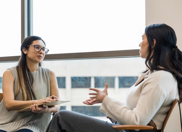 Person interviewing an employee in an office.