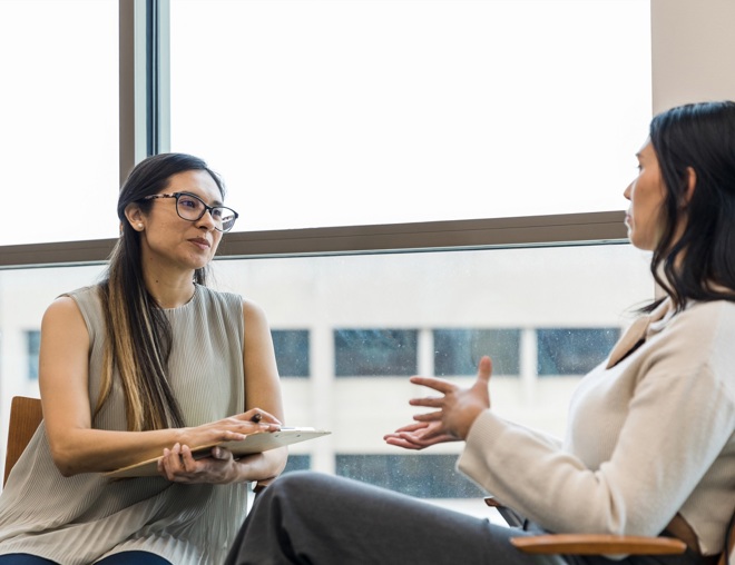 Person interviewing an employee in an office.