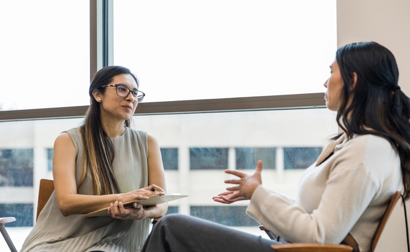 Person interviewing an employee in an office.