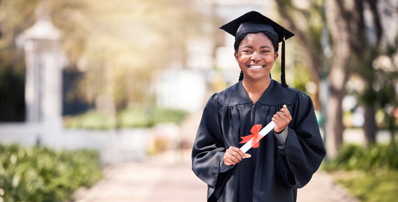 Student posing in cap and gown on high school graduation day.