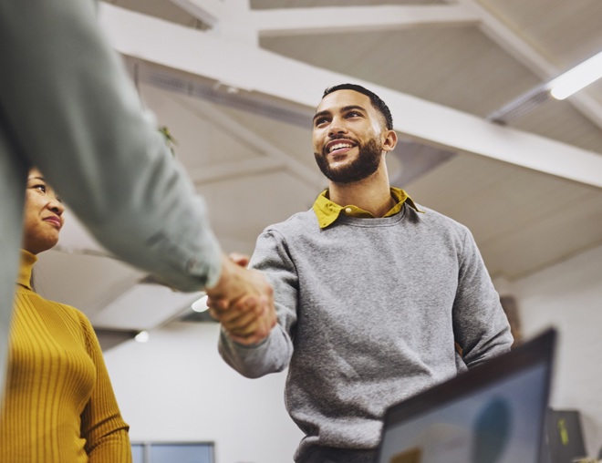 Two coworkers shaking hands.