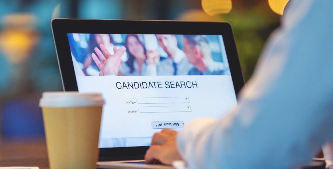 Employer using software on laptop to find candidates for job. 